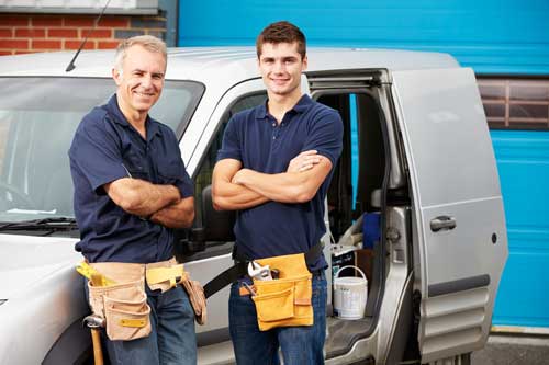 Two contractors standing next to a work van