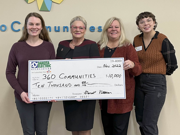 women holding a large check for $10,000