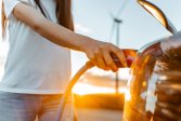 a woman's hand plugging in an electric vehicle