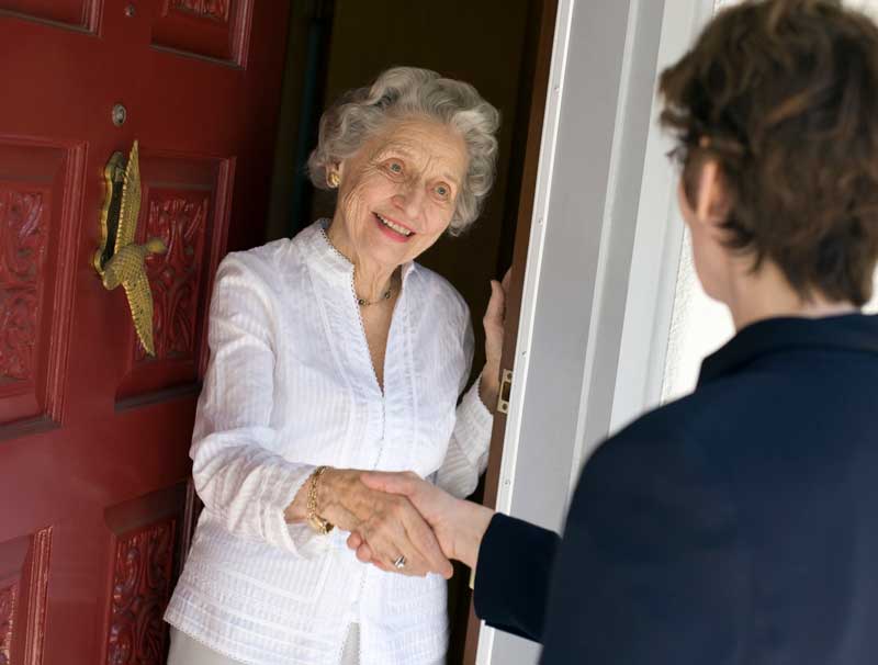 Woman greeting elderly neighbor