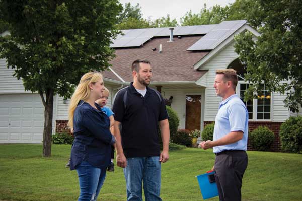 Pluto_Solar Energy services representative meeting with Dakota Electric members about their solar installation